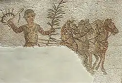 Mosaïque représentant un aurige habillé en rouge, tenant une couronne et une palme, avec quatre chevaux.