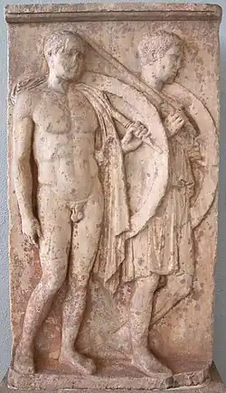 Persistance du classicisme polyclétéen: Stèle funéraire des soldats Chairédèmos (à gauche, figuré en soldat-athlète / nudité héroïsante) et Lyséas (figuré simplement en soldat, à droite). Marbre H. 1,81&nbsp;m. Après 409 (?). Le Pirée[N 10]