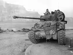 photographie en noir et blanc d’un char avec des soldats dessus