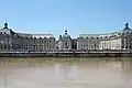 Place de la Bourse, bordée par l'hôtel des douanes à gauche, et le palais de la Bourse à droite, vue de la Garonne.