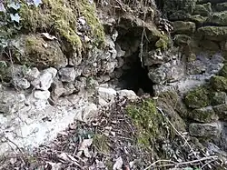 Photographie en couleurs d'un canal maçonné partiellement enchâssé dans la roche naturelle.