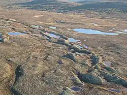 Longue butte de sédiments sur un terrain plat.
