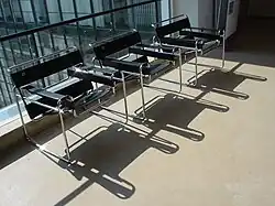 Trois chaises Wassily devant une paroi vitrée.