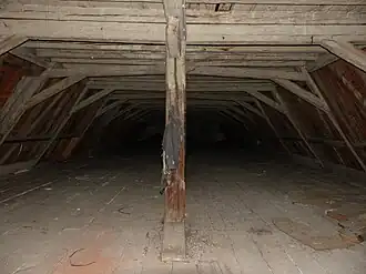 Photographie d'un combles à la charpente en bois.