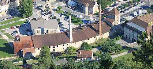 Photographie en couleurs prise en altitude au-dessus d'un site industriel : bâtiments bas, hautes tours.