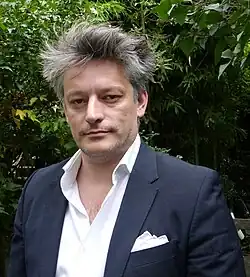 Portrait photographique d'un homme en costume.