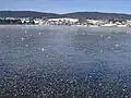 Vue de la commune avec le lac gelé en premier plan.