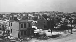 Photo couleur d'un quartier résidentiel vu de haut. Les maisons présentent toute une forme ou une autre de dégât.