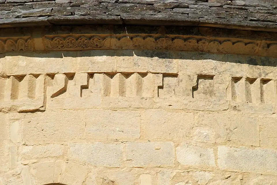 Frise de dents d'engrenage mêlée de motifs inspirés de la « grecque ».
