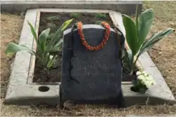 La tombe est décorée d'un collier de fleurs.