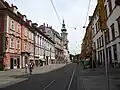 Herrengasse vue du nord. À droite se trouve l'Armurerie d'État, en arrière-plan deux tramways et le Marienlift, une installation artistique (2006).