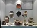 Poteries, assiettes et lampes à huile puniques derrière une vitrine de protection