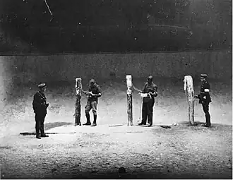 Après la Libération, des soldats FFI et un policier parisien inspectent la chambre d'exécution située dans la cave de l'édifice de l'ancien ministère de l'Air.