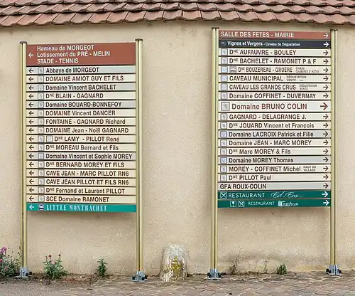 Panneaux dans le centre du village, indiquant la direction de multiples exploitations viticoles.