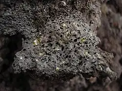 Exemple de basalte de type tholéiitique. Ici : une olivine provenant du piton de la Fournaise, sur l'île de La Réunion.