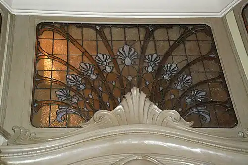Fleuron en stuc et vitrail surmontant la porte du Museum Café.