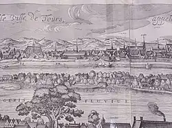 Dessin en noir et blanc d'une ville au bord d'un cours d'eau.