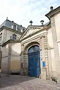 Portail sur la rue du Chapitre et bâti de l'escalier d'honneur en arrière-plan.