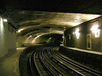Les quais de la station en courbe, abandonnée.