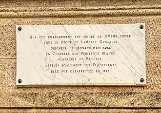 Plaque commémorative sur le palais de justice rappelant l'histoire de la chapelle.