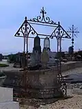 Vestige de fer forgé décorant une tombe du cimetière.