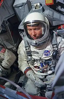 Photographie couleur de Shirra, assis en combinaison dans un simulateur.