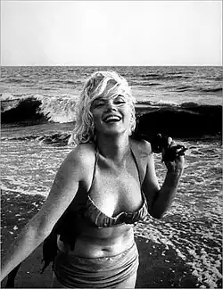Monroe sur une plage, portant un bikini et riant.