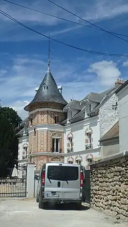 Photographie de profil d'un petit château se détachant sur un fond de ciel bleu.