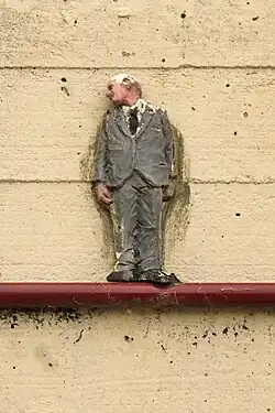 Statuette d'Isaac Cordal à l'arrière des Halles (voie des Hennuyers).