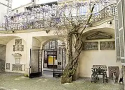 Cour de l’Hôtel de Ragueneau avec la glycine et les pièces d'architecture rapportées.