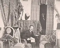 Photographie ancienne en noir et blanc d'un homme assis dans un canapé