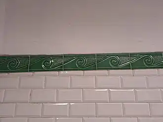 Détail des frises vertes à vagues dans le style « Nord-Sud ».