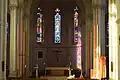 Le chœur de l'église, le prolongement de la nef et les vitraux.