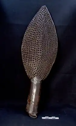 Râpe en forme de pointe de lance percée d'une infinité de petits trous.