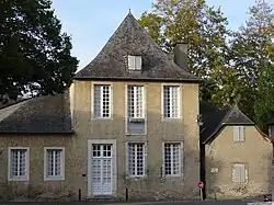 Photo d'une maison aux portes et fenêtres blanches et au toit en ardoise.