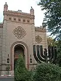 La synagogue chorale avec devant le monument aux morts de la Shoah.