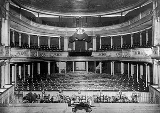 Photographie en noir et blanc de l'intérieur d'une salle de concert vide.