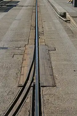 Un aiguillage sur la voie du TVR, à proximité de l'arrêt "Saint-Georges". Les deux rails étaient sur une plaque commune, qui pivotait en fonction du rail à aligner. Cet aiguillage était abandonné[11] depuis 2005, et a en conséquence été soudé sur le rail encore en service.