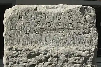Borne marquant la limite de la Voie Sacrée à Athènes. La fin de l'inscription d'origine, modifiée au Ve&nbsp;siècle&nbsp;av. J.-C., se lit ΗΟΡΟΣ ΤΕΣ ΟΔΟ ΤΕΣ ΕΛΕΥΣΙΝΑΔΣΙ (« Borne de la route d'Éleusis »). Vers 520 av. J.-C.. Trouvée dans le lit de l'Éridanos. Musée archéologique du Céramique.