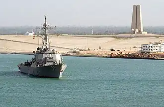 L'USS&nbsp;Mitscher passant devant le Monument à la Défense du Canal de Suez en 2003.