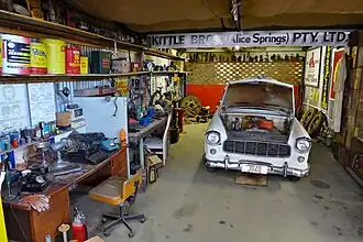 Une berline Holden (Holden FE&nbsp;(en) Special), exposée dans une reconstitution d'un atelier automobile.
