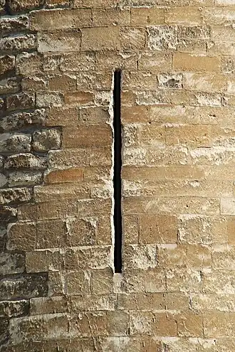 Meurtrière entourée de blocs de pierre de taille datant de la restauration de Jamaer (à gauche, les moellons d'origine).