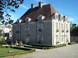 Photo d'un bâtiment de deux étages aux balcons fleuris.