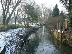 Vue de la rivière l’Yvette et des berges enneigées en hiver.