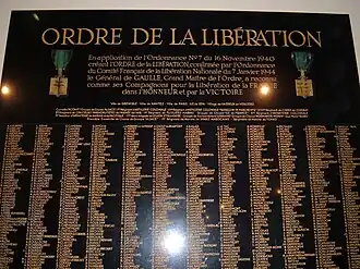 Photo d'une grande plaque de marbre noir portant sur douze colonnes, en lettres d'or, les noms des compagnons de la Libération