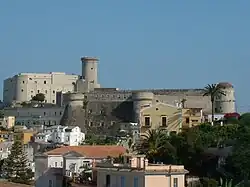 Photo d'un imposant château-fort entouré de maisons d'habitation.