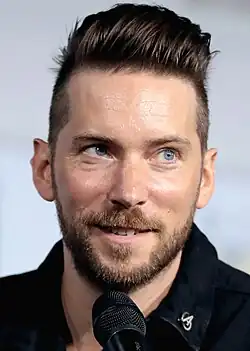 42 year-old man looking to the left of the camera.