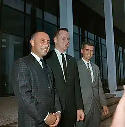 Photographie couleur des trois hommes d'équipage souriant et en costumes.