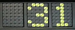 3 zones composées de disques noirs pouvant afficher des caractères en se retournant, ici le chiffre 36 en jaune fluo.