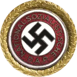 Une croix gammée entourée d'un insigne circulaire doré.
